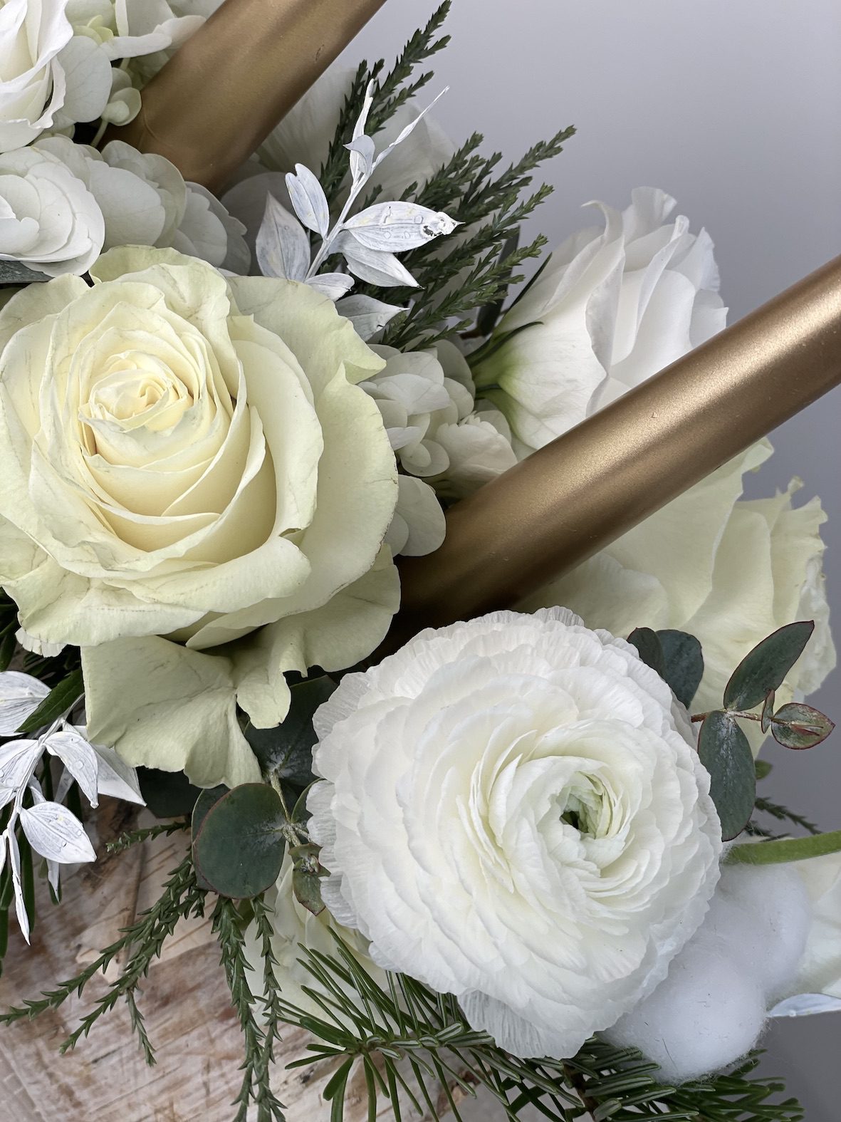 détail bûchette fleurie blanches roses blanches renoncules blanches bougies dorée
