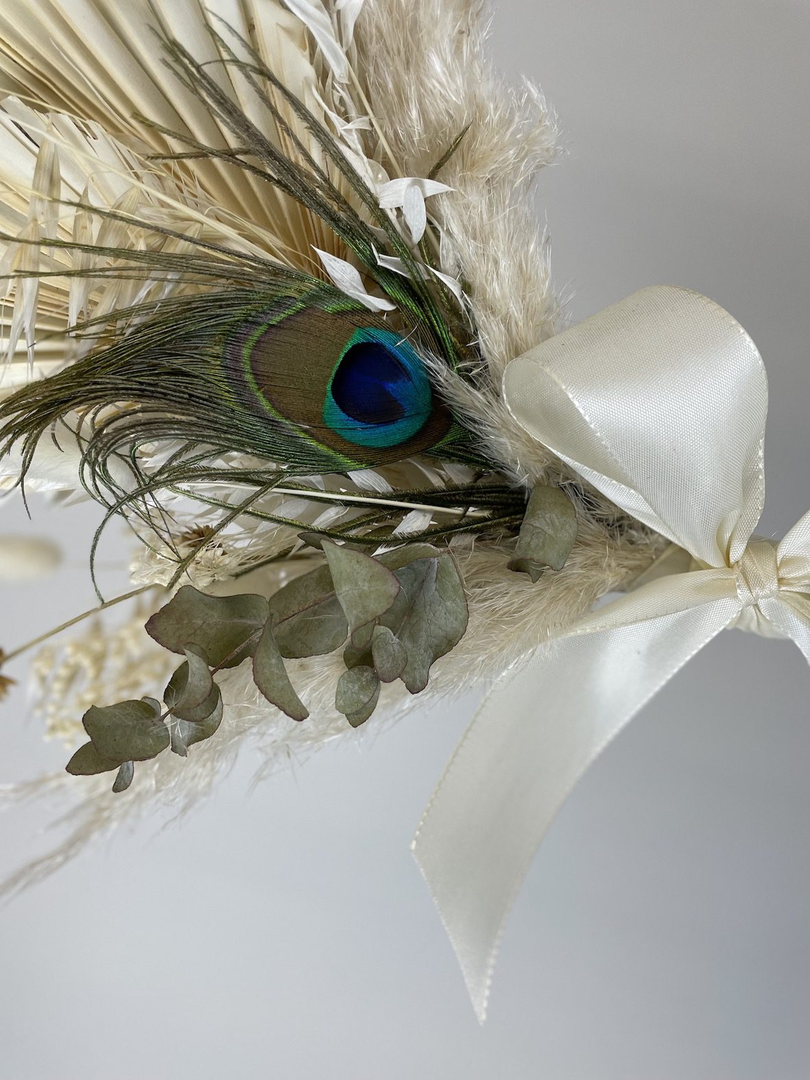 détail couronne fleurs séchée plume de paon noeud satin ivoire