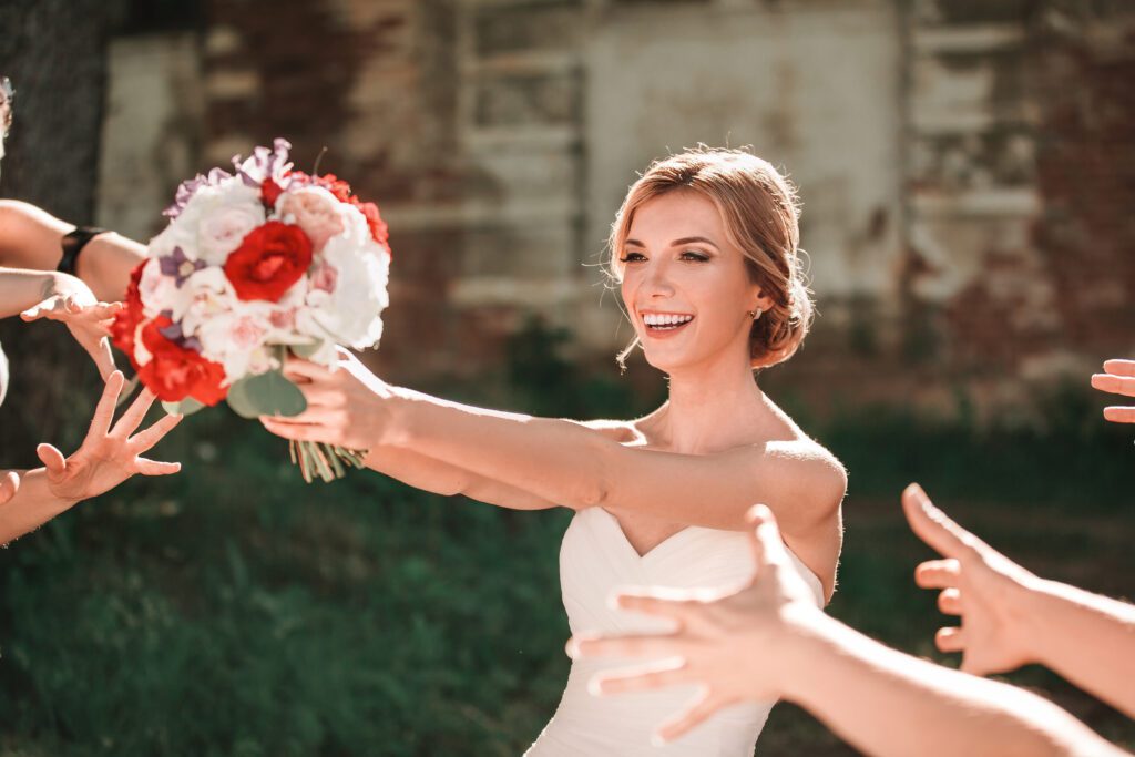 belle mariée jette un bouquet de mariage à ses amis