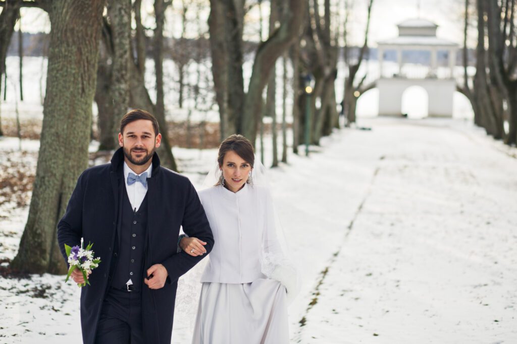 Couple de mariés marchant sur la neige en hiver.