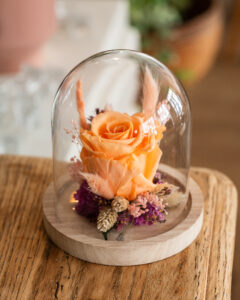 Rose stabilisée orange sous cloche en verre avec socle en bois, composition florale artisanale fabriquée à la main à Lyon, hauteur 15 cm.