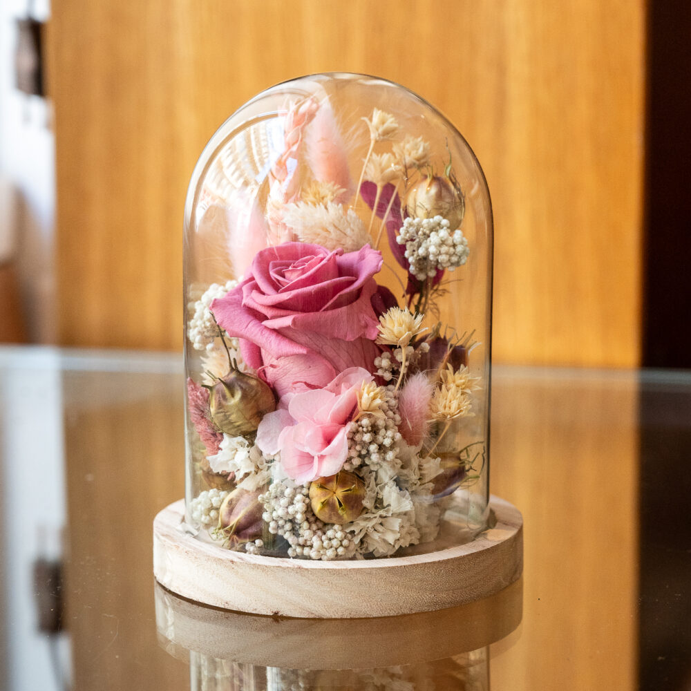 Rose stabilisée rose sous cloche en verre avec socle en bois, composition florale artisanale faite main à Lyon.