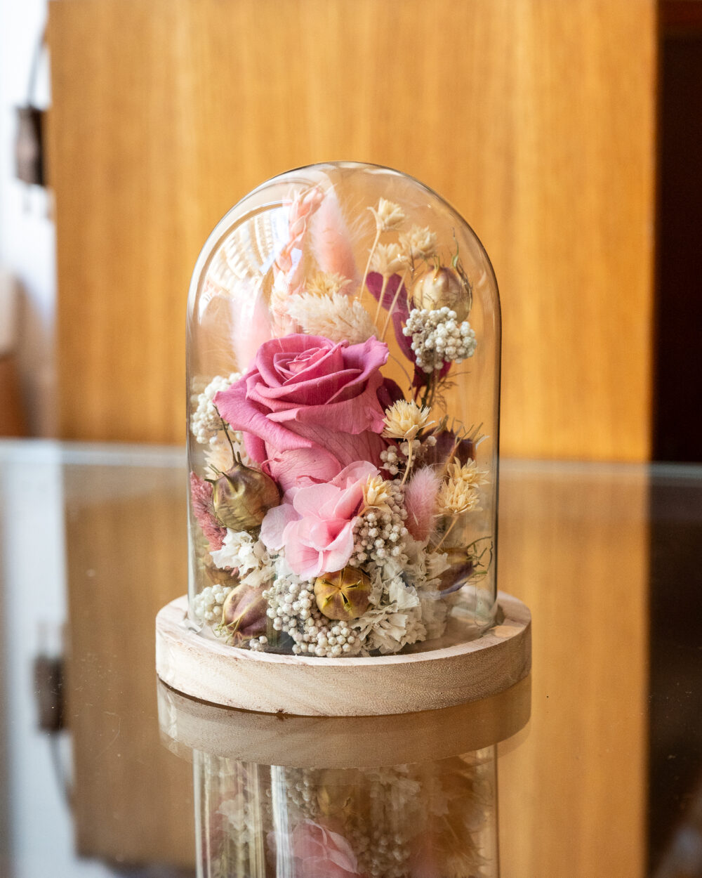 Rose stabilisée rose sous cloche en verre avec socle en bois, composition florale artisanale faite main à Lyon.