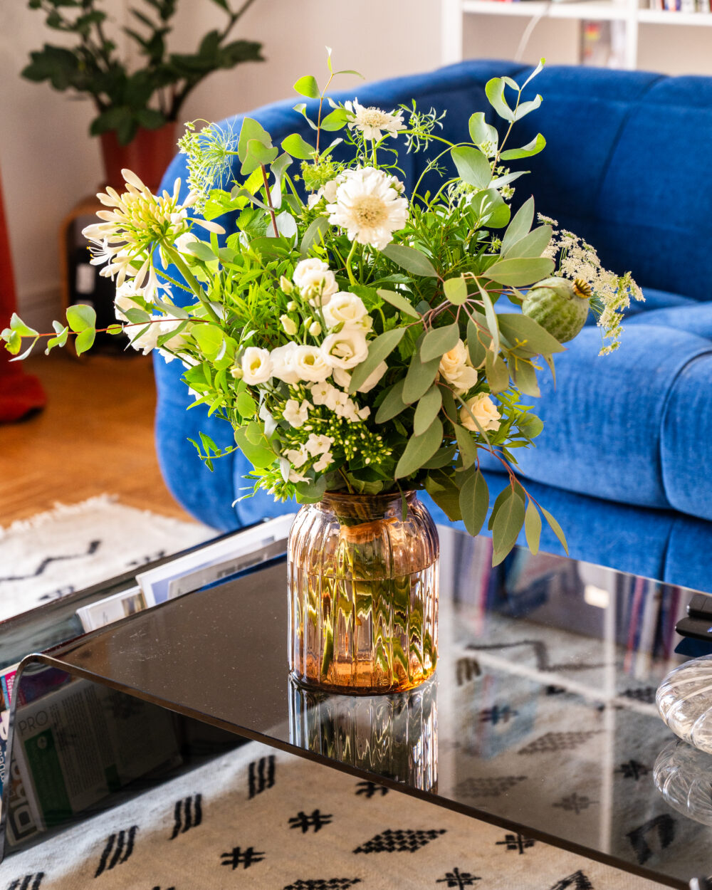 Vase en verre côtelé couleur pêche sur table basse, avec bouquet de fleurs fraîches – Atelier Lavarenne Lyon