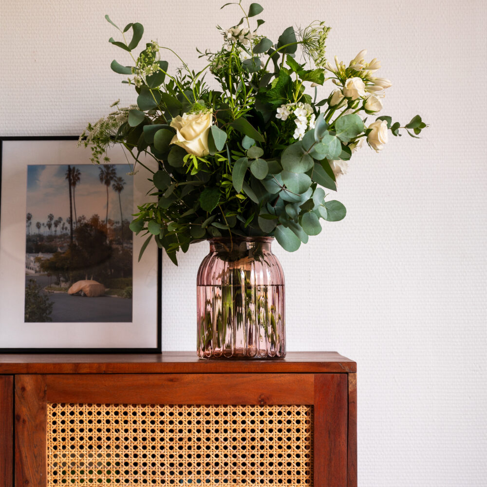 Ce vase en verre rose poudré aux courbes côtelées est idéal pour des bouquets de 25 à 40 cm. Une pièce délicate pour sublimer vos fleurs, fraîches ou séchées.