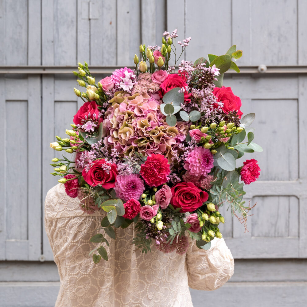 Bouquet du mois d’octobre spécial Octobre Rose composé de roses fuchsia, hortensias roses, dahlias, œillets et feuillages, réalisé par un fleuriste à Lyon