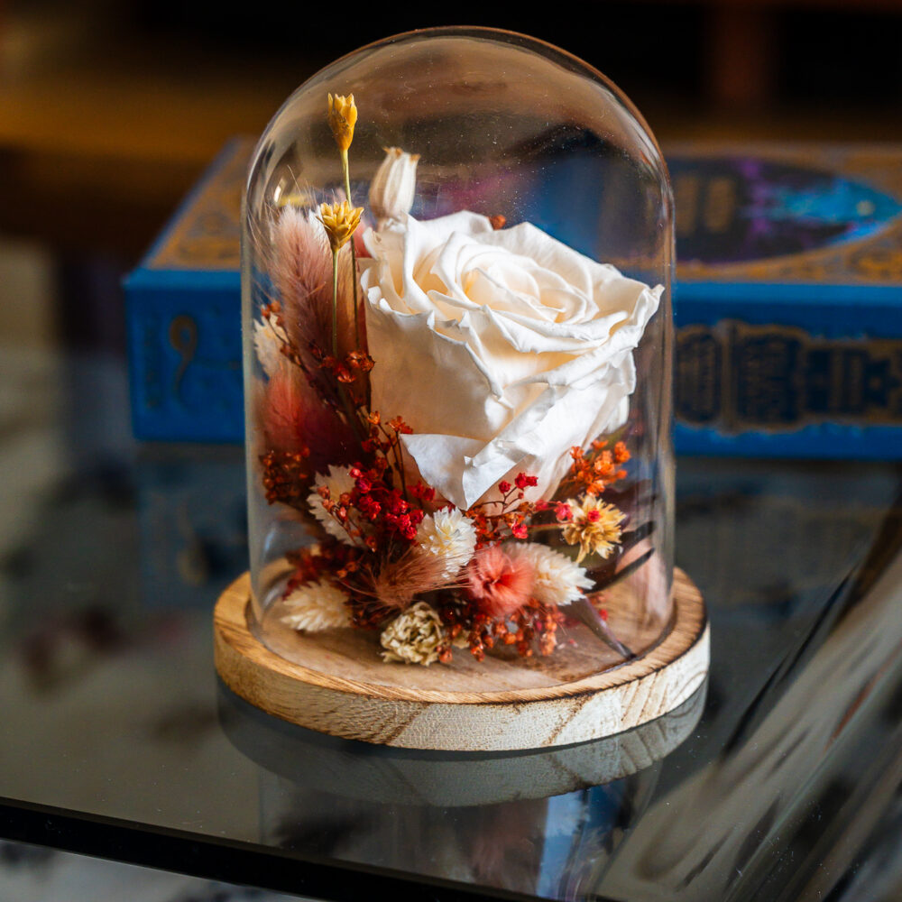 Cloche en verre avec rose stabilisée ivoire et fleurs séchées violettes sur base en bois, création artisanale Atelier Lavarenne Lyon